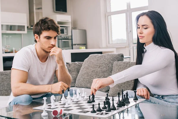 Красивая пара, играющая в шахматы во время самоизоляции дома — стоковое фото