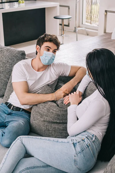 Casal doente em máscaras médicas falando em casa durante o auto-isolamento — Fotografia de Stock