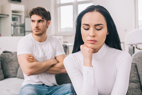 Sad offended couple sitting on sofa after argument during self isolation at home — Stock Photo