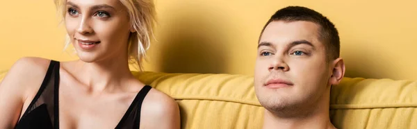 Smiling couple in bed on yellow background, panoramic crop — Stock Photo