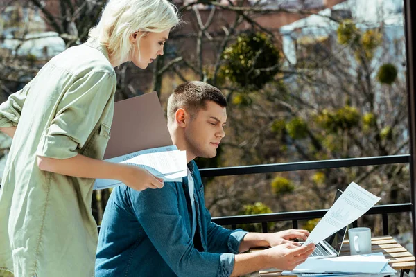 Бізнесмени працюють з ноутбуком і паперами на сонячній терасі — стокове фото