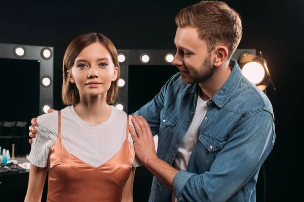 Handsome makeup artist embracing beautiful model in photo studio — Stock Photo