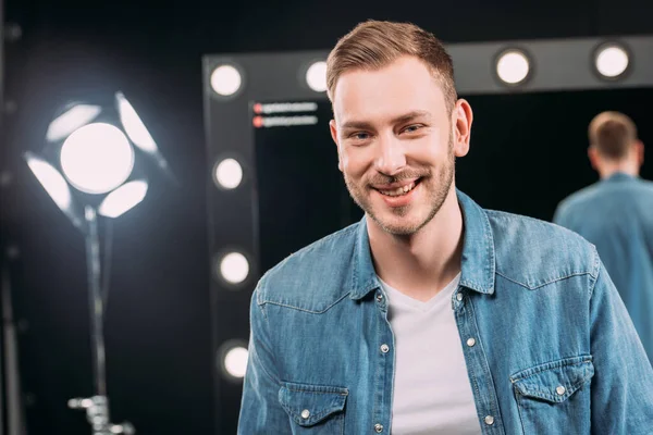 Bellissimo truccatore sorridente alla macchina fotografica in studio fotografico — Foto stock