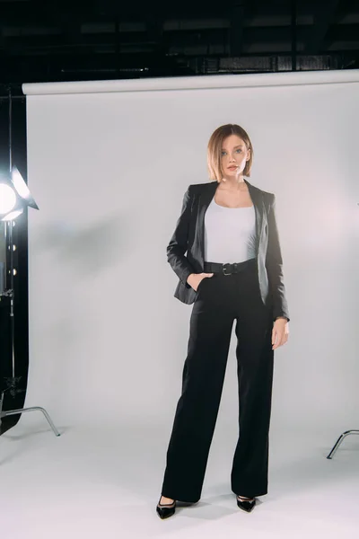 Beautiful model in formal wear looking at camera in photo studio — Stock Photo