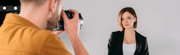 Prise de vue panoramique d'un beau mannequin posant chez un photographe avec appareil photo numérique en studio photo — Photo de stock