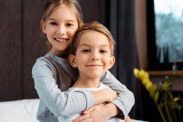 Fröhliche Schwester umarmt glücklichen Bruder zu Hause — Stockfoto