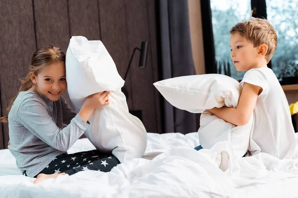 Mignon frères et sœurs oreiller combat dans la chambre — Photo de stock