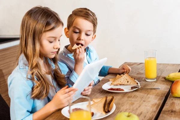 Collage de frères et sœurs e-learning et petit déjeuner à la maison — Photo de stock