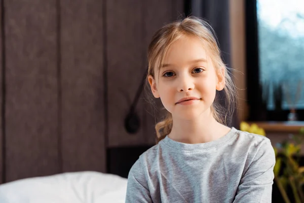 Cute child looking at camera and smiling at home — Stock Photo
