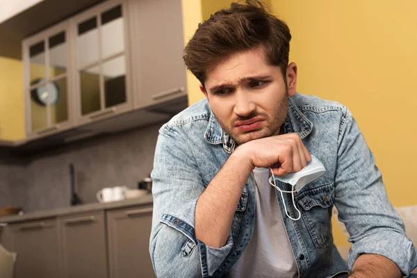 Trauriger Mann mit Arztmaske zu Hause — Stockfoto