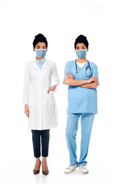 Afrikanisch-amerikanische Krankenschwester und Ärztin mit abgebildeten Gesichtern in medizinischen Masken auf weiß — Stockfoto