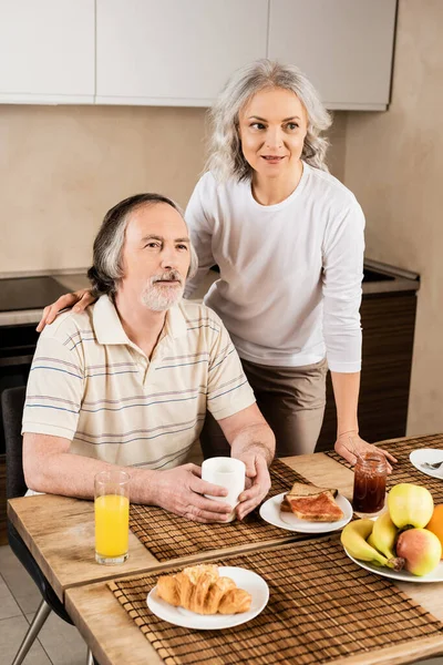 Heureux couple mature près de délicieux petit déjeuner — Photo de stock