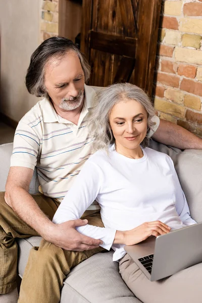 Happy and mature freelancers using laptop at home — Stock Photo