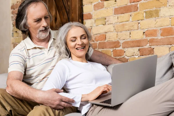 Cheerful and mature freelancers using laptop at home — Stock Photo