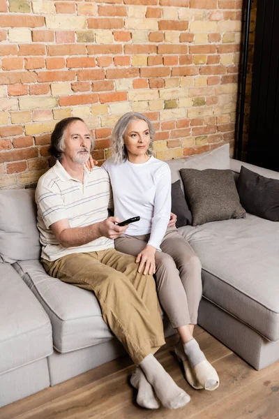 Middle aged couple watching movie in living room — Stock Photo