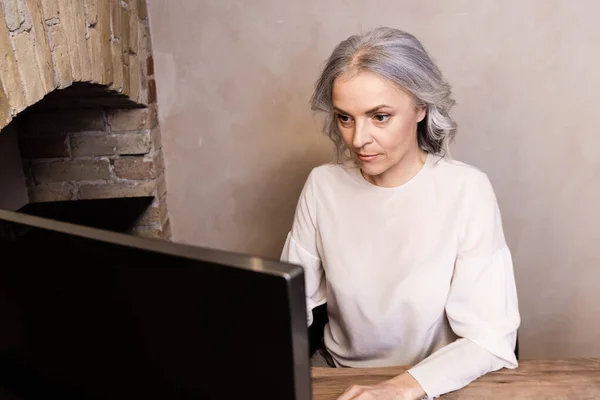 Вибірковий фокус жінки середнього віку, що працює з дому — стокове фото