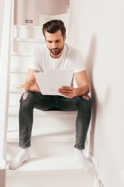 Schöne Freiberuflerin arbeitet zu Hause mit Papieren auf der Treppe — Stockfoto