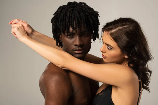 Bonito apaixonado multiétnico casal abraço isolado no cinza — Fotografia de Stock