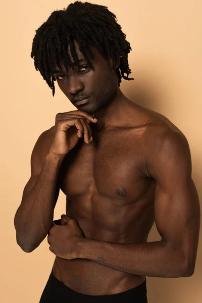 Sexy shirtless young african american man on beige — Stock Photo