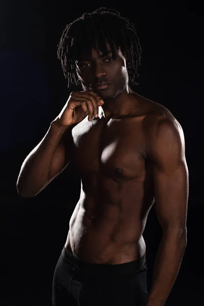 Sexy sin camisa muscular africano americano hombre aislado en negro con luz de fondo - foto de stock