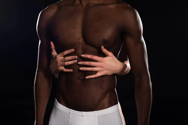 Partial view of girlfriend hugging sexy african american boyfriend isolated on black — Stock Photo