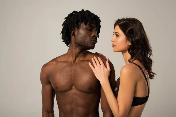 Passionate multicultural couple hugging isolated on grey — Stock Photo