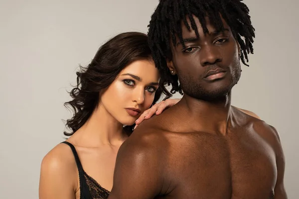 Schön sexy interracial paar umarmt isoliert auf grau — Stockfoto