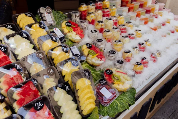 Fresh fruits in containers with price tags in ice on counter of outdoor shop — Stock Photo