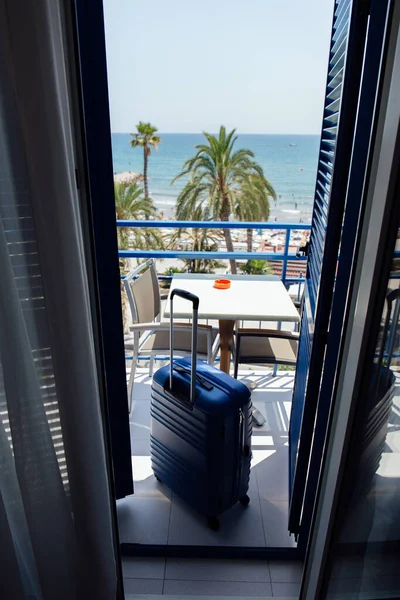 Suitcase on balcony with palm trees and seascape at background in Catalonia, Spain — Stock Photo