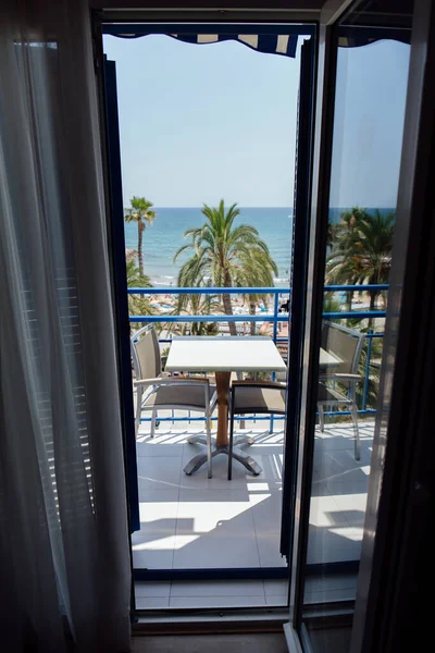 Tisch und Stühle auf Balkon mit Palmen und Meerblick im Hintergrund in Katalonien, Spanien — Stockfoto