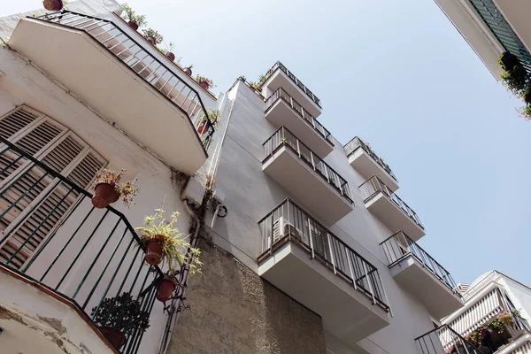 Vue en angle bas des façades blanches des bâtiments avec un ciel bleu à l'arrière-plan en Catalogne, Espagne — Photo de stock