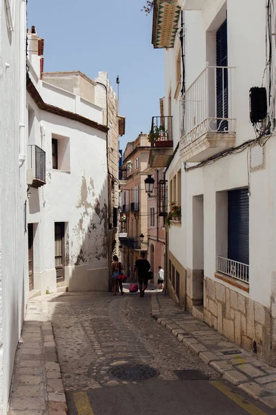KATALONIEN, SPANIEN - 30. APRIL 2020: Menschen gehen auf städtischen Straßen mit Pflastersteinen auf dem Gehweg — Stockfoto