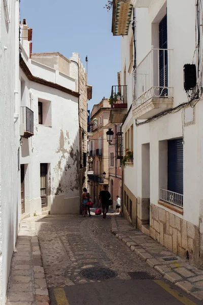 KATALONIEN, SPANIEN - 30. APRIL 2020: Menschen gehen auf städtischen Straßen mit Pflastersteinen auf dem Gehweg — Stockfoto