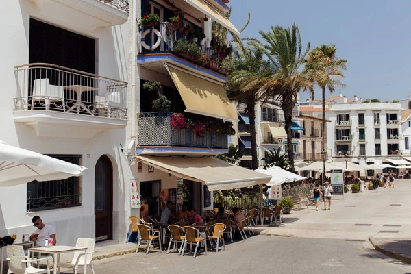 Каталония, Испания - 30 апреля 2020 года: Городская улица с открытым кафе и пальмами в Каталонии — стоковое фото