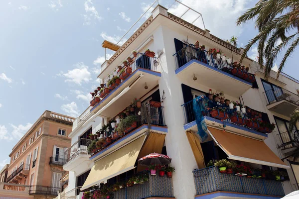 Vue en angle bas des fleurs sur le balcon de la maison avec ciel nuageux en arrière-plan, Catalogne, Espagne — Photo de stock