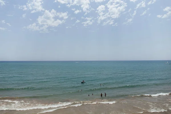 Gente nadando en el mar cerca del barco en la costa de Cataluña, España - foto de stock