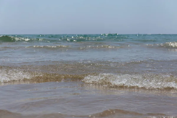 Concentration sélective des vagues de mer avec un ciel bleu en arrière-plan en Catalogne, Espagne — Photo de stock