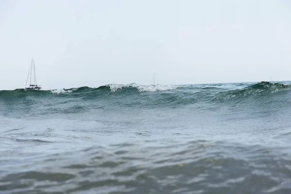 Surface level of yachts in sea with waves and blue sky at background, Catalonia, Spain — Stock Photo