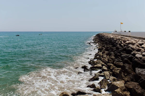 Paysage marin avec jetée et pierres sur fond clair en Catalogne, Espagne — Photo de stock
