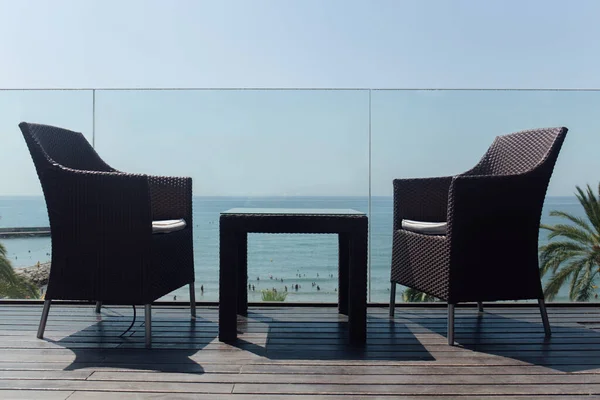 Niedriger Blickwinkel auf Tisch und Stühle in der Nähe von Glaszäunen und Meereslandschaft im Hintergrund in Katalonien, Spanien — Stockfoto
