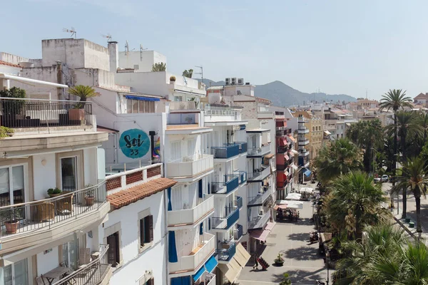 КАТАЛОНІЯ, SPAIN - APRIL 30, 2020: міська вулиця з будівлями, пальмами та горами з синім небом на задньому плані. — стокове фото