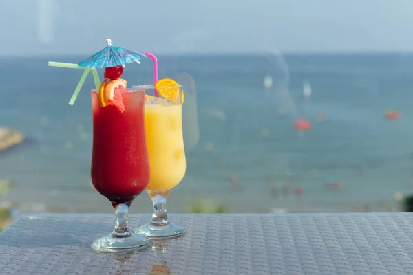 Окуляри коктейлів на столі з морем і блакитним небом на фоні — стокове фото