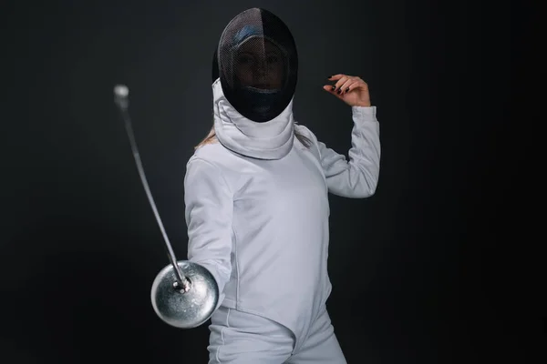 Selective focus of fencer holding rapier isolated on black — Stock Photo