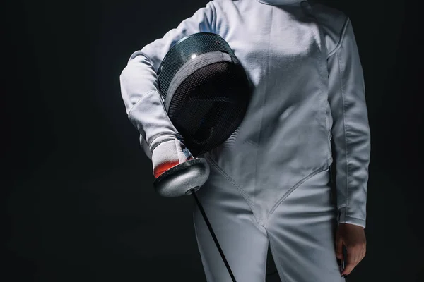 Cropped view of fencer holding fencing mask and rapier isolated on black — Stock Photo