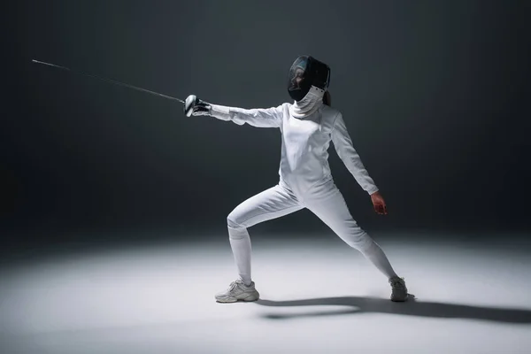 Fencer training with rapier on white surface on black background — Stock Photo