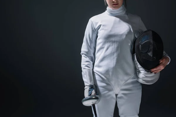 Cropped view of fencer holding fencing mask and rapier isolated on black — Stock Photo
