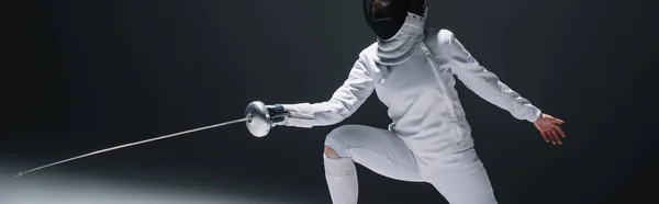 Horizontal image of fencer training with rapier on black background — Stock Photo