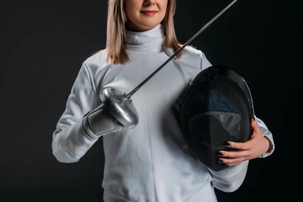 Cropped view of swordswoman holding rapier and fencing mask isolated on black — Stock Photo