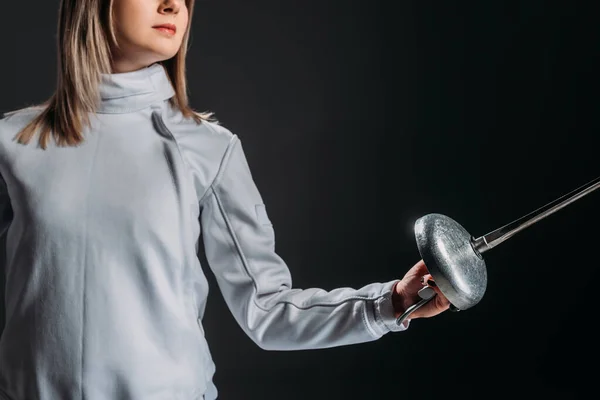 Vista recortada de esgrima en traje de esgrima sosteniendo estoque aislado en negro - foto de stock