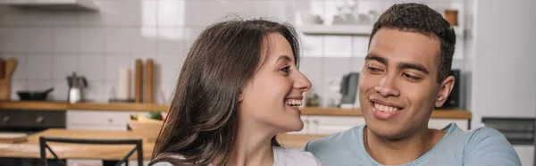 Horizontal image of happy woman looking at mixed race boyfriend at home — Stock Photo